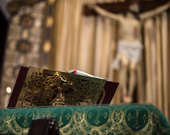 Close-up of bible against statue at church