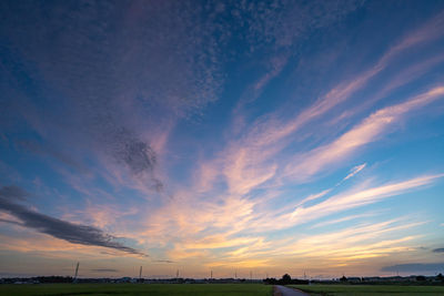 Scenic view of dramatic sky over land during sunset