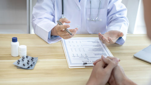 Midsection of doctor examining patient at clinic