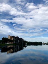 Buildings by lake against sky