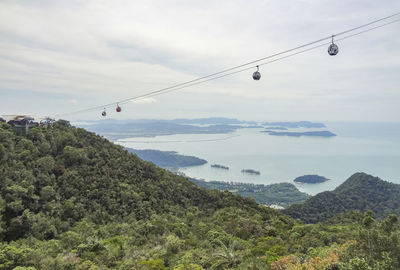 Overhead cable car over mountains against sky