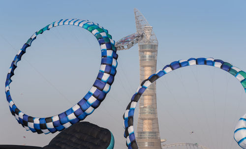 Low angle view of ferris wheel against clear blue sky