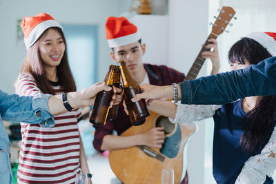 Friends toasting beer bottles during celebration at home