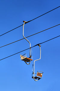 Low angle view of ski lift against clear sky