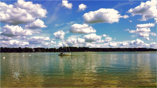 Boats in sea against cloudy sky