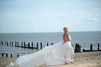 Woman standing on beach against sea