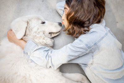 Midsection of woman with dog relaxing on blanket