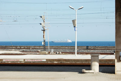 Street light by sea against clear sky