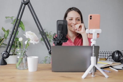 Young woman using mobile phone on table