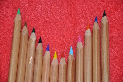 Close-up of colored pencils against red background