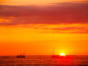 Scenic view of sea against dramatic sky during sunset