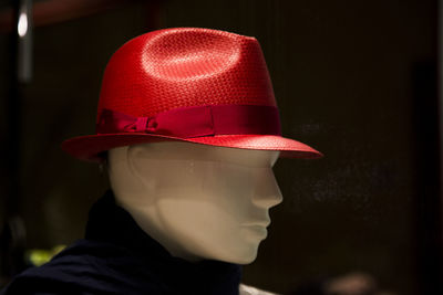 Close-up of mannequin wearing hat against black background