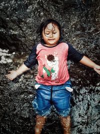 Full length of a smiling girl on rock