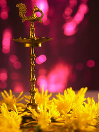 Close-up of diya amidst yellow flowers