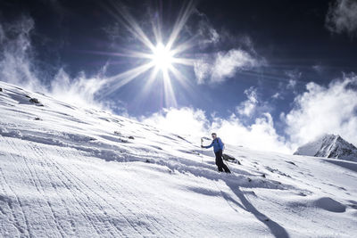 Man skiing on snowcapped mountain against sky