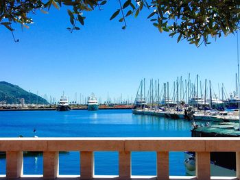 Swimming pool by sea against clear blue sky