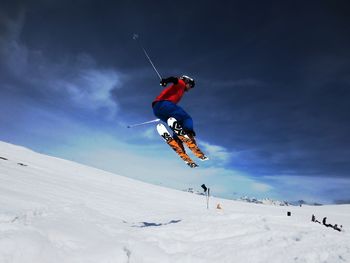 Low angle view of young man snowboarding in winter