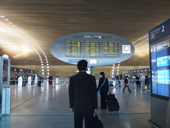 Rear view of people walking in airport