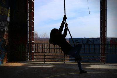 Side view of person swinging on rope at teufelsberg