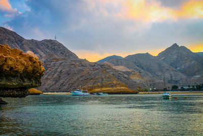 Scenic view of a cove and mountains against sky during sunset