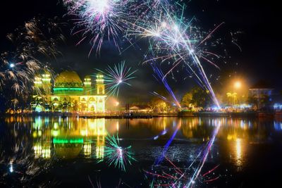 Firework display over river at night