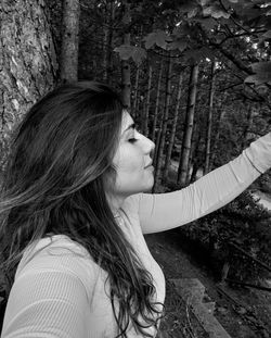 Woman looking at tree trunk