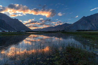 Scenic view of lake by mountains against sky