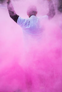 Rear view of man standing against pink wall
