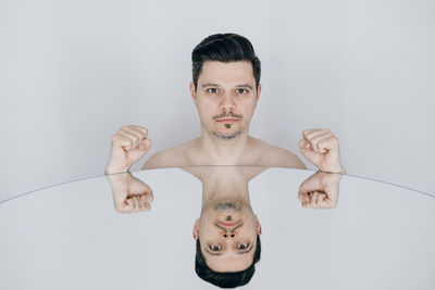 Portrait of shirtless man against white background