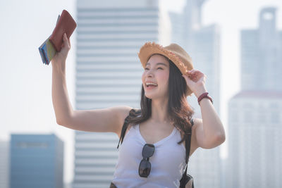 Young woman wearing hat standing against the wall