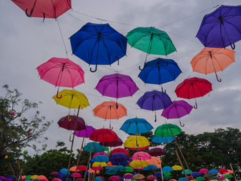 Low angle view of umbrellas hanging against sky