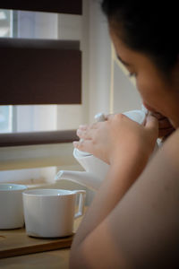 Midsection of woman holding coffee cup