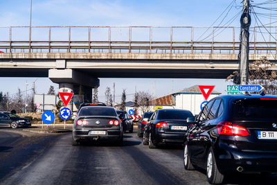 Cars on bridge in city against sky