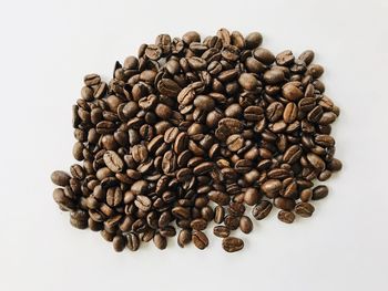 High angle view of coffee beans against white background