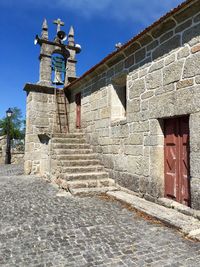 Steps by bell tower at old church against sky