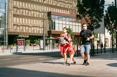 Full length of people walking on street in city