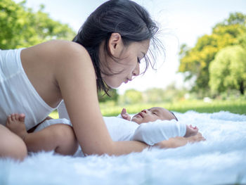 Happy woman lying down while relaxing outdoors