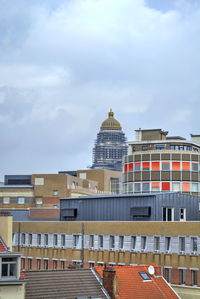 Buildings in city against cloudy sky