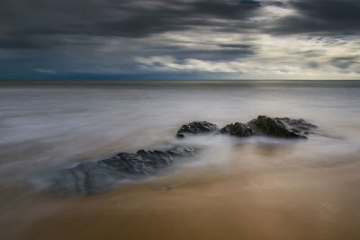 Scenic view of sea against cloudy sky