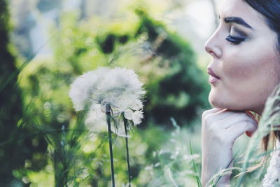 Close-up of young woman holding plant