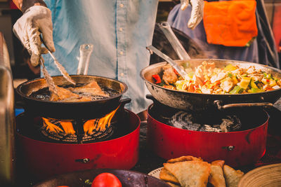 Midsection of man frying food in cooking pan