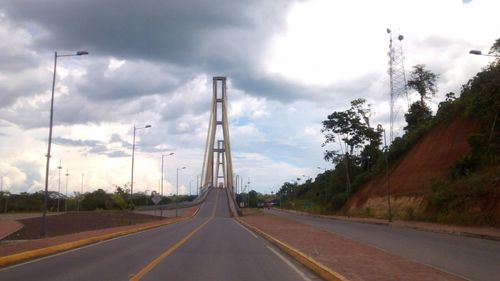 Empty road against cloudy sky