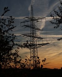 Low angle view of silhouette electricity pylon against sky during sunset