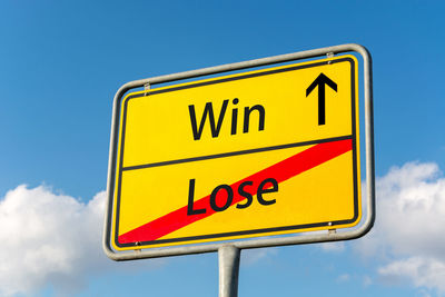 Low angle view of road sign against blue sky