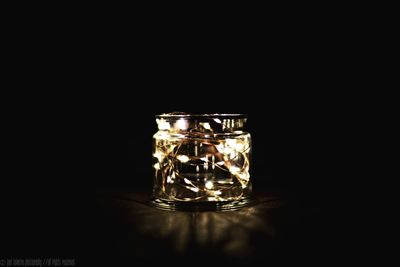 Close-up of illuminated lamp against black background