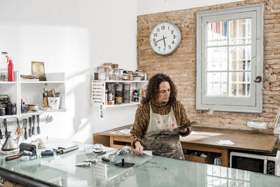 Female artist inspecting a plate and preparing it for a handmade