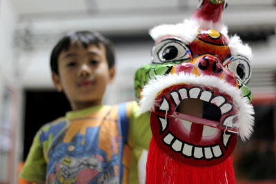 Close-up portrait of boy with his barangsay toys against blurred background