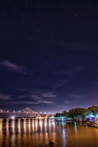 Scenic view of lake against sky at night