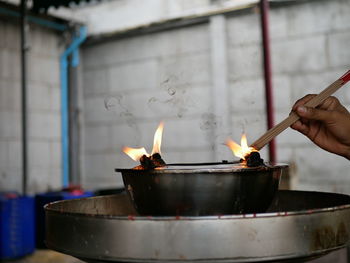 Person holding burning candles in temple