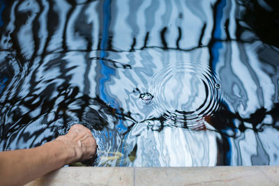 Cropped hand of person in pond